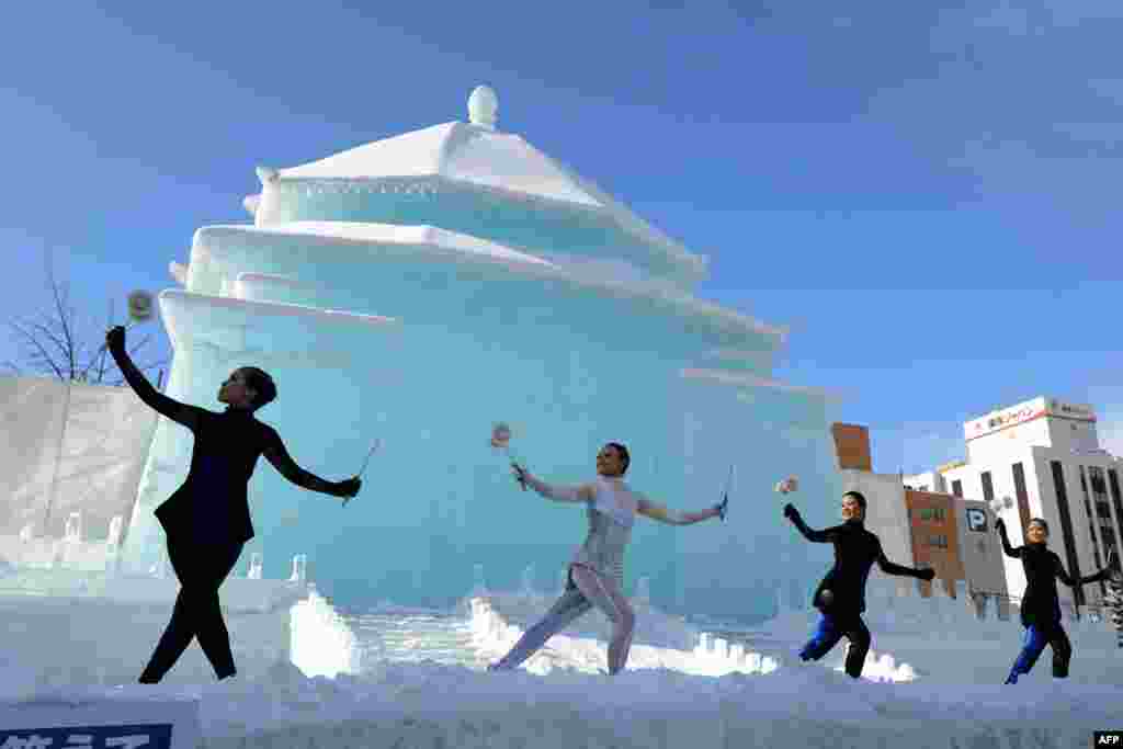 Para penari dari Taiwan tampil di depan patung salju besar di Chiang Kai-shek Memorial Hall pada pembukaan festival salju tahunan di Sapporo, Hokkaido, Jepang.