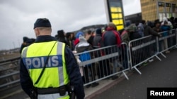 C'est à Malmo, où ici des migrants débarquent à la station de Hyllie en présence policière, qu'un Syrien sunnite est accusé d'avoir mis le feu à un centre chiite, en Suède.