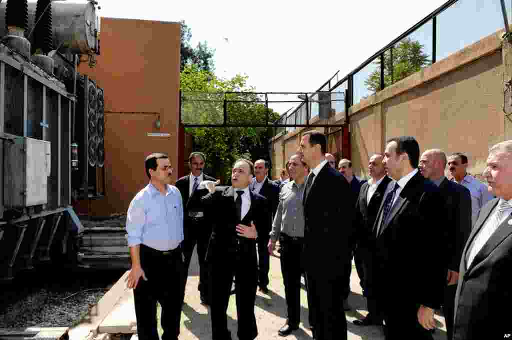 This photo released by the Syrian official news agency SANA shows Syrian President Bashar al-Assad visiting the Umayyad Electrical Station, Damascus, Syria, May 1, 2013. 