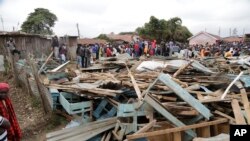 People and rescuers walk on debris of The Precious Talent Top School in Nairobi, Kenya, Sept. 23, 2019. 