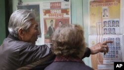 A Chinese couple look at a newspaper reporting on new General Secretary of Communist Party of China Xi Jinping and other members of the party leadership in Beijing, China, Nov. 16, 2012. 