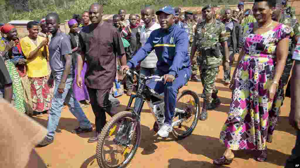 Pierre Nkurunziza arrive à bicyclette, accompagné par la Première dame burundaise, Denise Bucumi Nkurunziza, pour voter, Ngozi, 21 juillet 2015. 