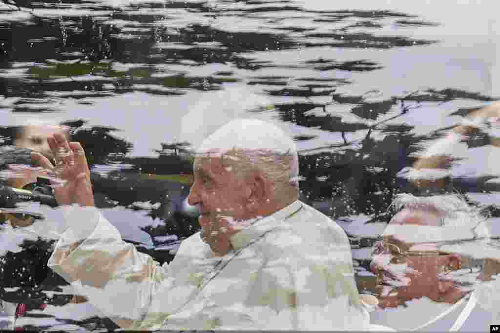 Pope Francis waves from a pope mobile at the Cercle-Cite convention center in Luxembourg after a meeting with the national authorities and the civil society on the first day of Francis's four-day visit to Luxembourg and Belgium.