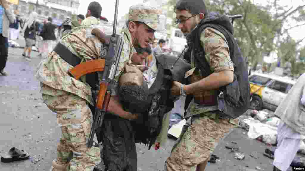 Une victime de l’attentat suicide portée par les agents de la sécurité après l’explosion d’une bombe à Sanaa, Yémen, jeudi le 9 octobre 2014. REUTERS