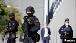 Polisi mengamankan pintu masuk gedung pengadilan saat pembukaan persidangan serangan Paris Januari 2015 majalah satir mingguan Charlie Hebdo, seorang polisi wanita di Montrouge dan supermarket halal Hyper Cacher, di Paris, Perancis, 2 September 2020.