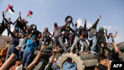 Des manifestants palestiniens brandissent leur drapeau national à la frontière entre Israël et Gaza, le 27 avril 2018