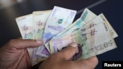 Un empleado cuenta pesos colombianos en una tienda en Bogotá, Colombia, el 28 de diciembre de 2018.