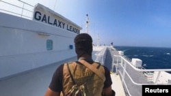 Seorang anggota kelompok pemberontak Houthi berjaga di atas kapal kargo Galaxy Leader di Laut Merah dalam foto yang dirilis pada 20 November 2023. (Foto: Houthi Military Media/Handout via Reuters)