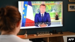 Une famille française regarde à Lille la déclaration du président Emmanuel Macron, faite depuis le palais de l'Élysée à Paris, sur la pandémie de COVID-19, le 14 juin 2020.