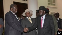 Riek Machar, ancien vice-président du Soudan du Sud, à gauche, salue le président sud-soudanais Salva Kiir en présence du président ougandais Yoweri Museveni lors d’une réunion de sécurité visant à trouver une solution durable, à Entebe, Ouganda, 7 juillet 2018.