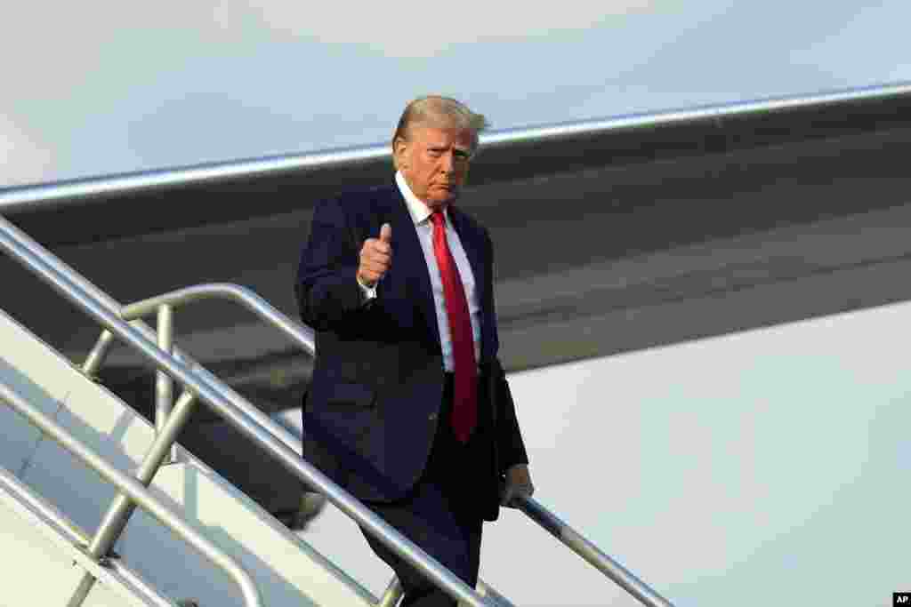 លោក Donald Trump បានលើកមេដៃឡើងពេលចុះពីយន្តហោះនៅអាកាសយានដ្ឋានអន្តរជាតិ Hartsfield-Jackson Atlanta កាលពីថ្ងៃទី២៤ ខែសីហា ឆ្នាំ ២០២៣។