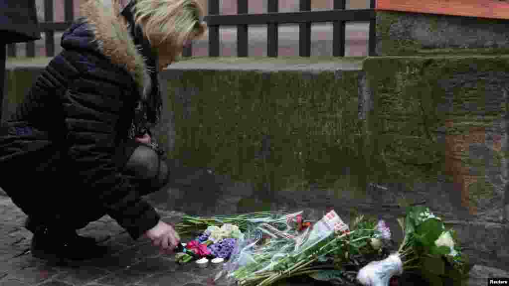 Une femme allume une bougie en face de la synagogue de Krystalgade à Copenhague, le 15 février 2015.