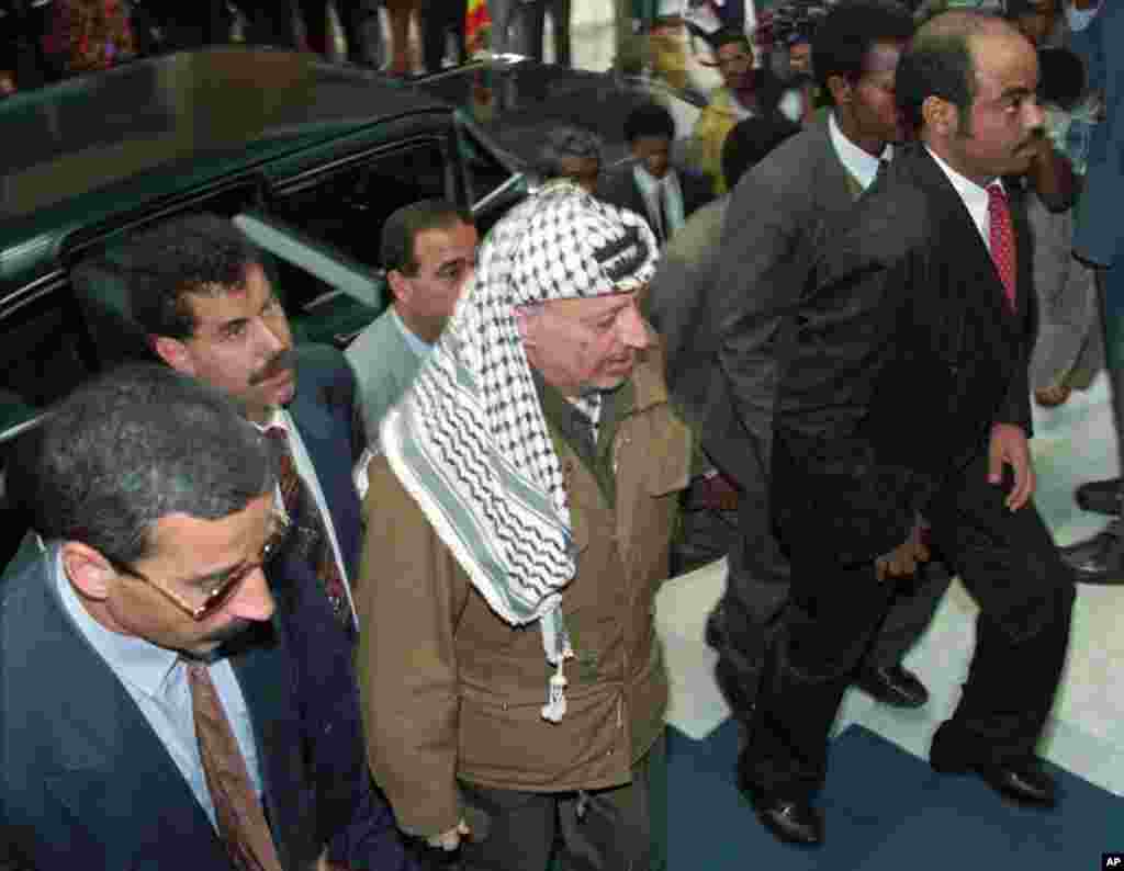 Meles accompanies Palestinian leader Yasser Arafat as he arrives at Addis Ababa's African Hall to attend a meeting, June 26, 1995.