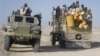 East African civilians depart in a truck, right, as AMISOM forces advance on al-Shabab-controlled region, Somalia, Sept. 4, 2012.