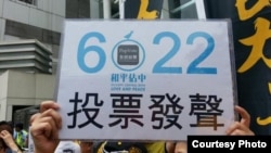 香港市民在中聯辦前高舉和平佔中運動6/22全民投票牌（網絡圖片）