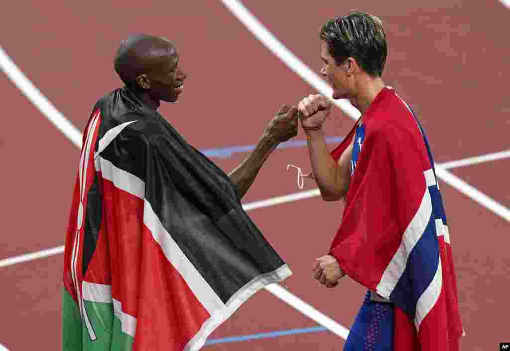 Jakob Ingebrigtsen, of Norway, right, celebrates with Timothy Cheruiyot, of Kenya, silver, after winning the gold medal in the final of the men's 1,500-meters at the 2020 Summer Olympics, Saturday, Aug. 7, 2021, in Tokyo, Japan. (AP Photo/Charlie Riedel)