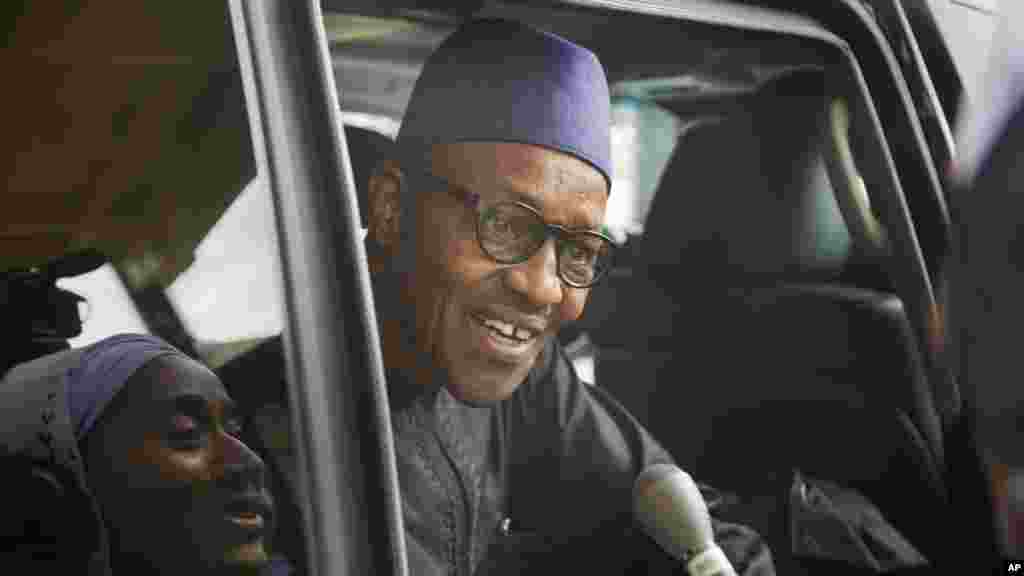Le principal candidat de l'opposition nigériane, le général Muhammadu Buhari, accroché par des journalistes, répond à quelques questions, assis dans son véhicules, après le renouvellement de l’engagement conjoint signé avec le président Goodluck Jonathan pour des élections "libres, justes et crédibles".