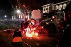 Un artefacto incendiario estalla frente a un vehículo de la policía durante las protestas en Kenosha, Wisconsin, el 25 de agosto de 2020.