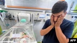 Ayman Abu Shamalah stoji pored svoje ćerke Meke, dok joj se zbrinjava u inkubatoru u bolnici u Rafi 23. oktobra 2023.