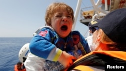 Seorang anak migran dipindahkan ke kapal Migran Offshore Aid Station (MOAS) berbasis Malta di Phoenix dalam operasi penyelamatan di Laut Mediterania tengah, perairan internasional di lepas pantai kota Sabratha, Libya, 4 Mei 2017. (Foto: dok).