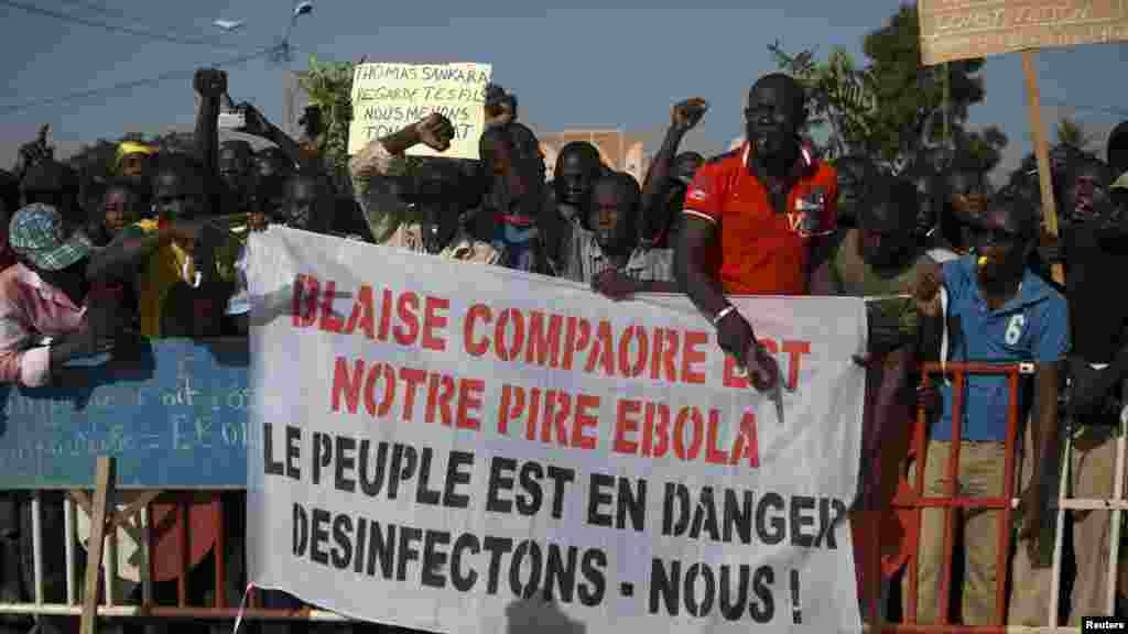 Des manifestants tiennent une banderole avec la mention : “Blaise Compaoré est notre Ebola“, sur la place de la Révolution, Ouagadougou, 28 octobre 2014. (REUTERS/Joe Penney)