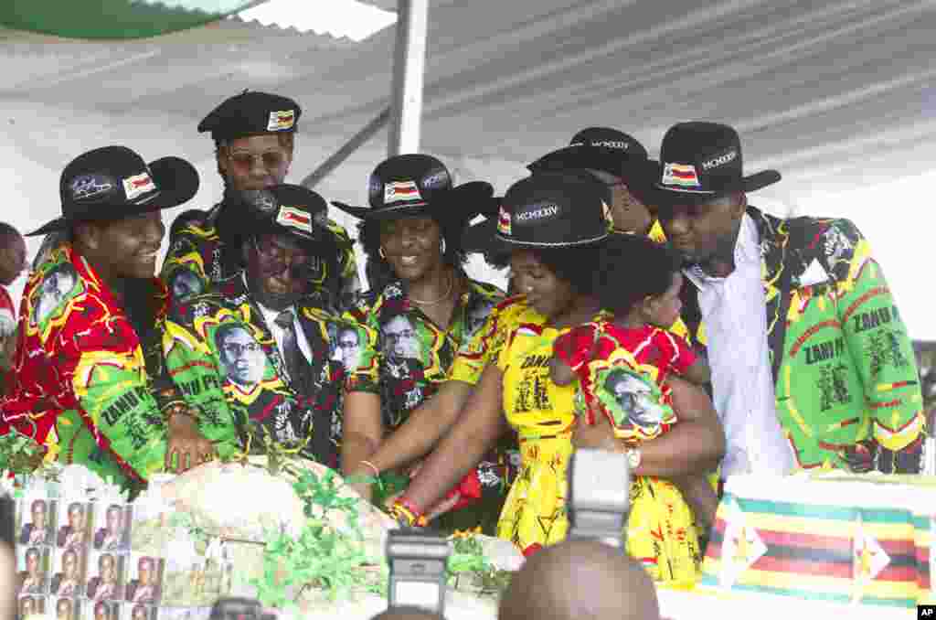 Le président zimbabwéen Robert Mugabe, centre gauche, son épouse Grace, au centre, et des membres de leur famille coupent le gâteau d'anniversaire à Matopos, dans la banlieue de Bulawayo, 25 février 2017.