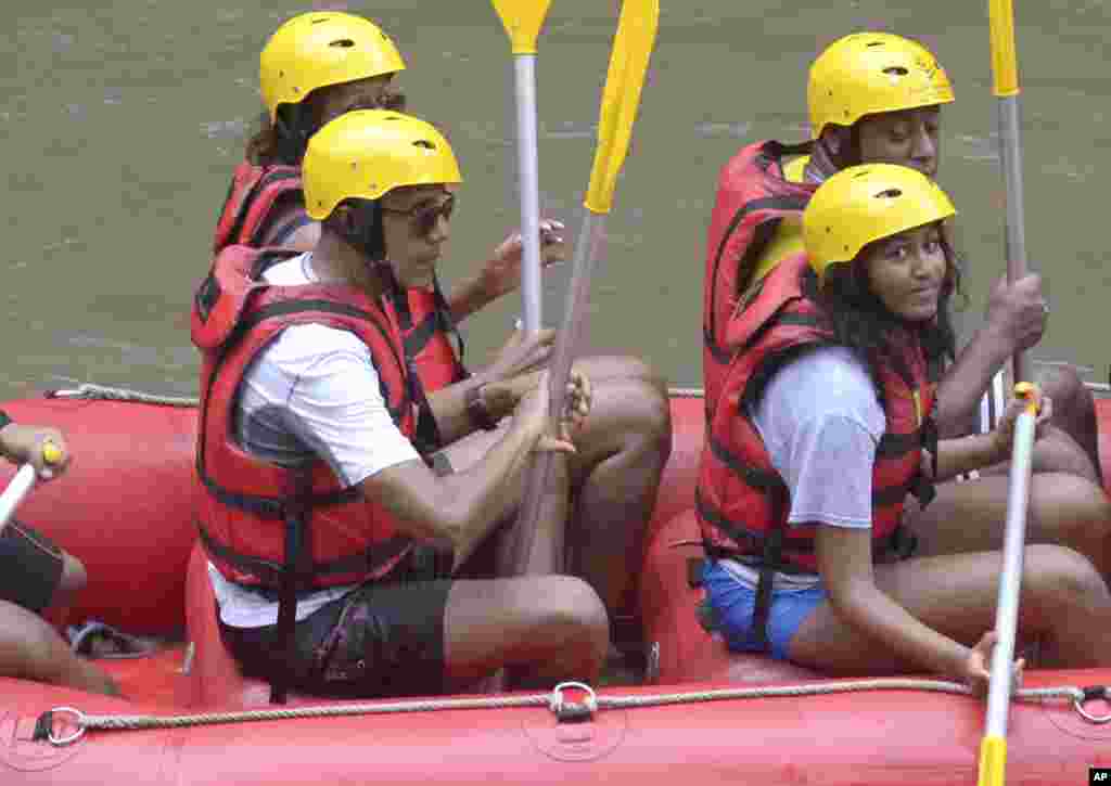 Barack Obama, à gauche, sa femme Michelle, à l'arrière gauche, et sa fille Sasha, à droite, pagaient, lors des vacances, sur la rivière Ayung à Badung, sur l'île de Bali, Indonésie, 26 juin 2017.