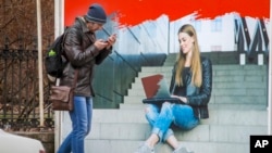 A man walks past an ads poster at an Internet devices shop in St.Petersburg, Russia, April 11, 2019. Russian lawmakers approved a bill that would expand government control over the internet and whose opponents fear heralds a new era of widespread censorship. 