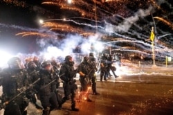 FILE - Police use chemical irritants and crowd control munitions to disperse protesters during a demonstration in Portland, Oregon, Sept. 5, 2020.