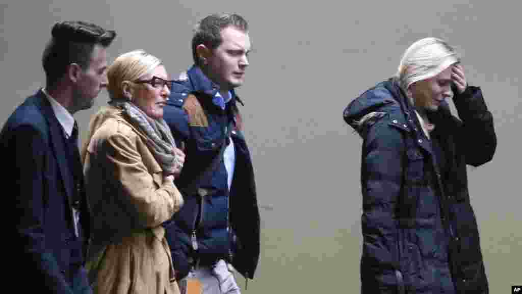 Quelques personnes pleurent à leur arrivée à l'aéroport de Duesseldorf, Allemagne, après le crash d'un avion de passagers de Germanwings transportant plus de 140 personnes dans les Alpes françaises mardi 24 mars 2015.