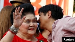 Philippines vice-presidential candidate Ferdinand "BongBong" Marcos, Jr. whispers to his mother, former First Lady and Congresswoman Imelda Marcos, before BongBong announced his candidacy in Manila, October 10, 2015.