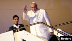 FILE - Pope Francis is seen waving as he boards his plane at Fiumicino airport in Rome, Jan. 12, 2015. 