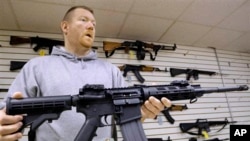 John Jackson, salah satu pemilik toko senjata api Capitol City Arms Supply menunjukkan senapan serbu AR-15 untuk dijual di toko miliknya di Springfield, Ill. (Foto: Dok)