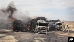 Para petugas berupaya memadamkan api yang membakar truk perbekalan NATO akibat serangan bom di Samangan, utara Kabul, Afghanistan (18/7). Konvoi perbekalan NATO kembali diserang sekelompok bersenjata di wilayah kesukuan Khyber, Jamrud-Pakistan (24/7).