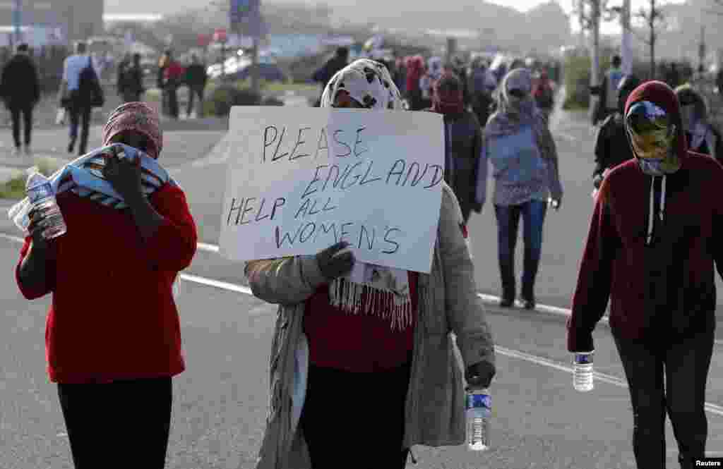 Para migran berdemonstrasi melawan pembongkaran kamp migran "The Jungle" di Calais, Perancis (25/10). (Reuters/Philippe Wojazer)