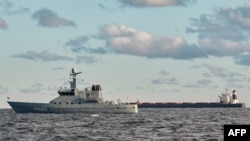 Kapal China, Yi Peng 3 (kanan) berlabuh dan dipantau oleh kapal patroli angkatan laut Denmark di laut Kattegat, dekat Kota Granaa di Jutland, Denmark, 20 November 2024. (Mikkel Berg Pedersen / Ritzau Scanpix / AFP)
