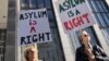 ARCHIVO - Manifestantes sostienen carteles en inglés que dicen "El asilo es un derecho" afuera del Tribunal Federal de San Francisco, el 24 de julio de 2019, en San Francisco, EEUU.