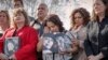 Rosie Cortinas (C) holding a photo of her son, Amador Cortinas, of Idaho, who was killed last year while driving a Chevy Cobalt, joins other families whose loved ones died behind the wheel of defective General Motors cars, in Washington, April 1, 2014.