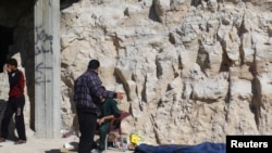 Warga berdiri di dekat mayat korban serangan yang diduga menggunakan gas beracun di kawasan Khan Sheikhoun, Idlib, Suriah, yang dikuasai oleh pemberontak, 4 April 2017.