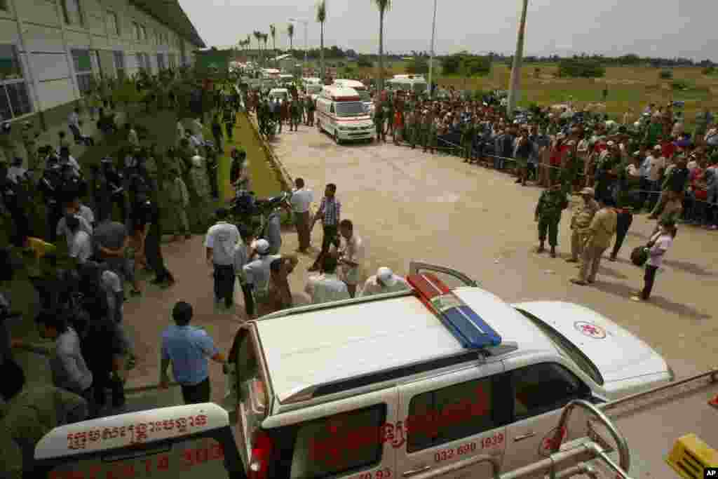 Ambulances park as they wait to transfer injured workers, at the site of a factory collapse in Cambodia, May 16, 2013.