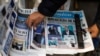 ARCHIVO - Una persona toma un periódico que anuncia la victoria del candidato presidencial Javier Milei en las primarias argentinas un día después de las elecciones, en Buenos Aires, Argentina, el 14 de agosto de 2023.