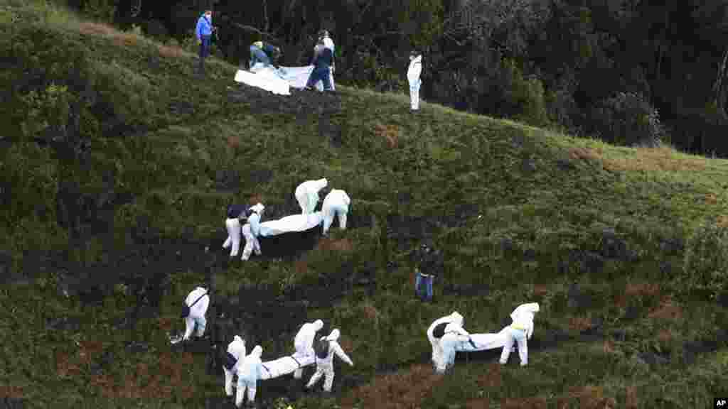 Les secouristes transportent les cadavres des victimes dans la zone montagneuse à l'extérieur de Medellin, en Colombie, le 29 novembre 2016.