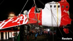 Bagian ekor pesawat AirAsia QZ8501 diangkat dari kapal ke truk di Pelabuhan Kumai, dekat Pangkalan Bun, Kalimantan Tengah (11/1). (Reuters/Darren Whiteside)