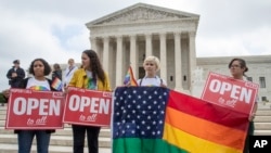 En esta foto del 4 de junio de 2018, los activistas de la American Civil Liberties Union se manifiestan ante el Tribunal Supremo en Washington.