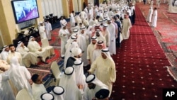 Kuwaitis queue at the Grand Mosque to pay their respects and condolences to the families of victims of a terrorist attack claimed by the Islamic State group on the Shiite Imam Sadiq Mosque in Kuwait City during Friday prayers, June 28, 2015.