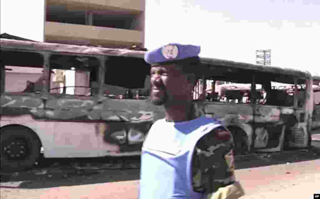 This image made from video released by UNSMIS, the UN observer mission in Syria and accessed June 9, 2012, purports to show a UN observer near a destroyed bus after overnight fighting in Damascus, Syria.