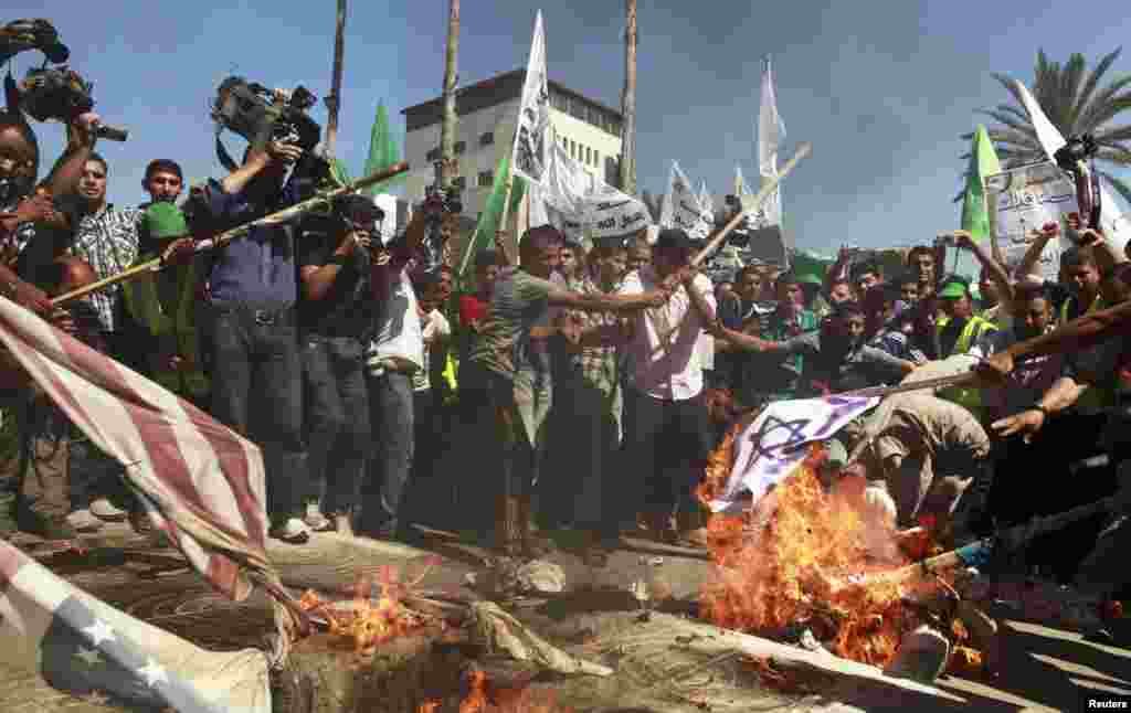 Palestinians burn U.S. and Israeli flags during a protest against a film produced in the U.S. that they said that was insulting to Prophet Muhammad, in Gaza City, September 14, 2012.