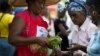 Kore Lavi participant buys food from program vendor. (Photo: USAID)