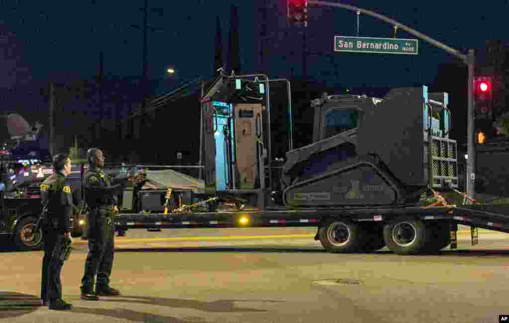 Les autorités de Californie se tiennent près d'un véhicule blindé près du lieu où la police a arrêté un véhicule suspect à San Bernardino, en Californie, 2 décembre, 2015. 