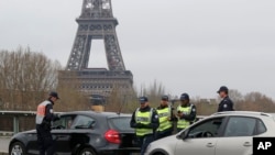 Polisi di kota Paris memeriksa kendaraan yang lewat di sepanjang sungai Seine, Senin (17/3). 